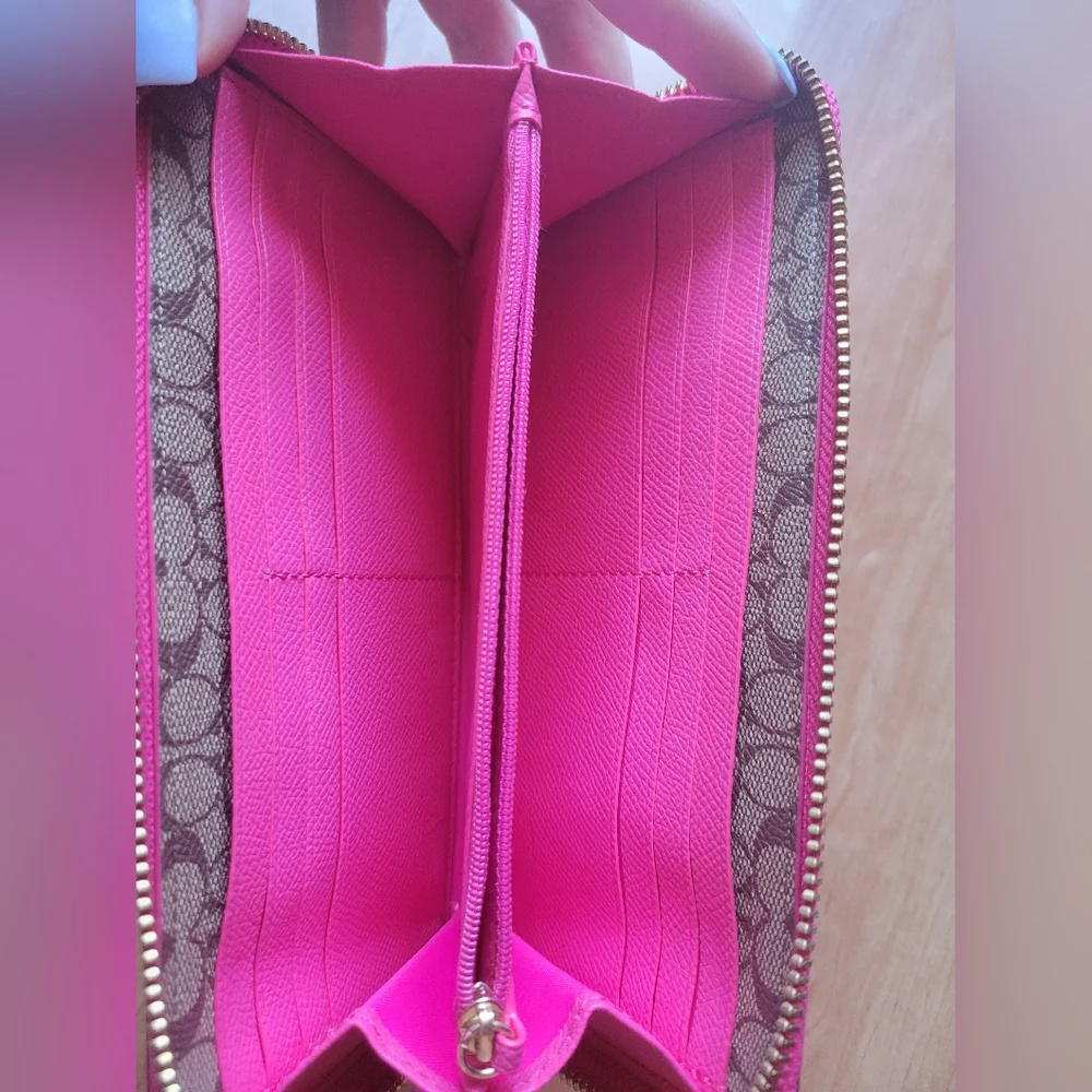 Coach Pink Leather Wallet with Gold Logo and Zip Closure.